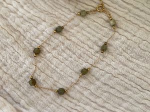 Bracelet doré et pierres vertes