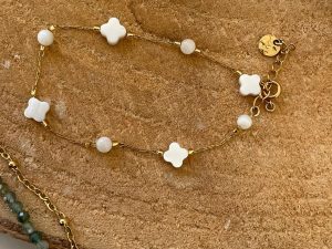 Bracelet doré et trèfle blanc