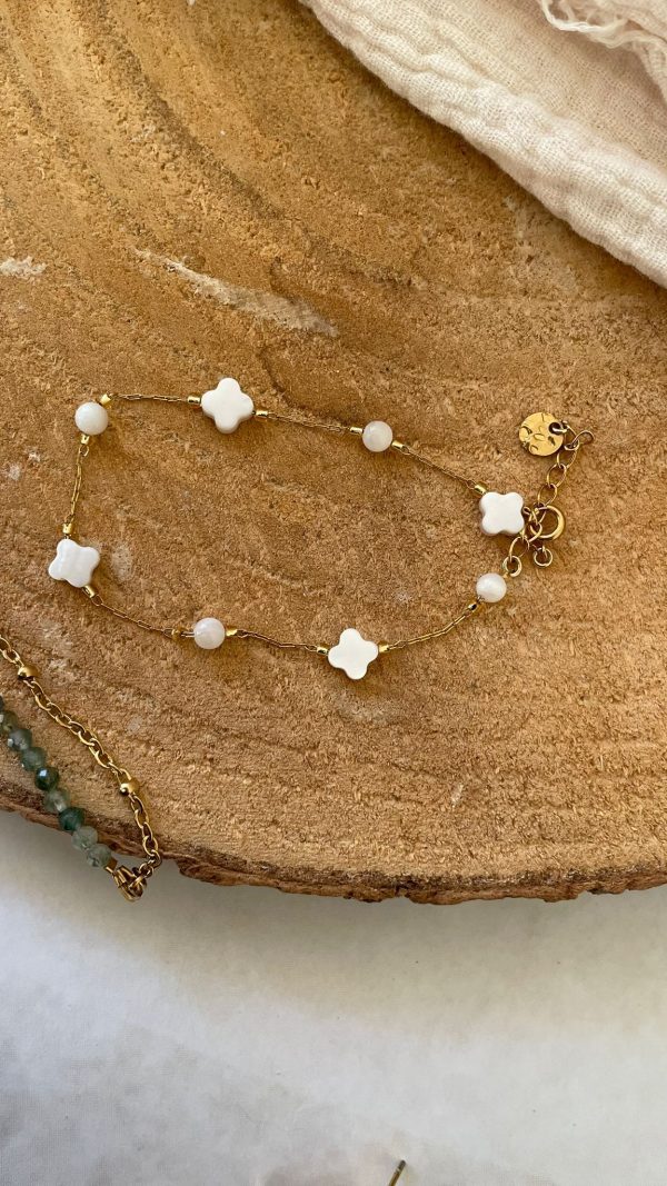 Bracelet doré et trèfle blanc